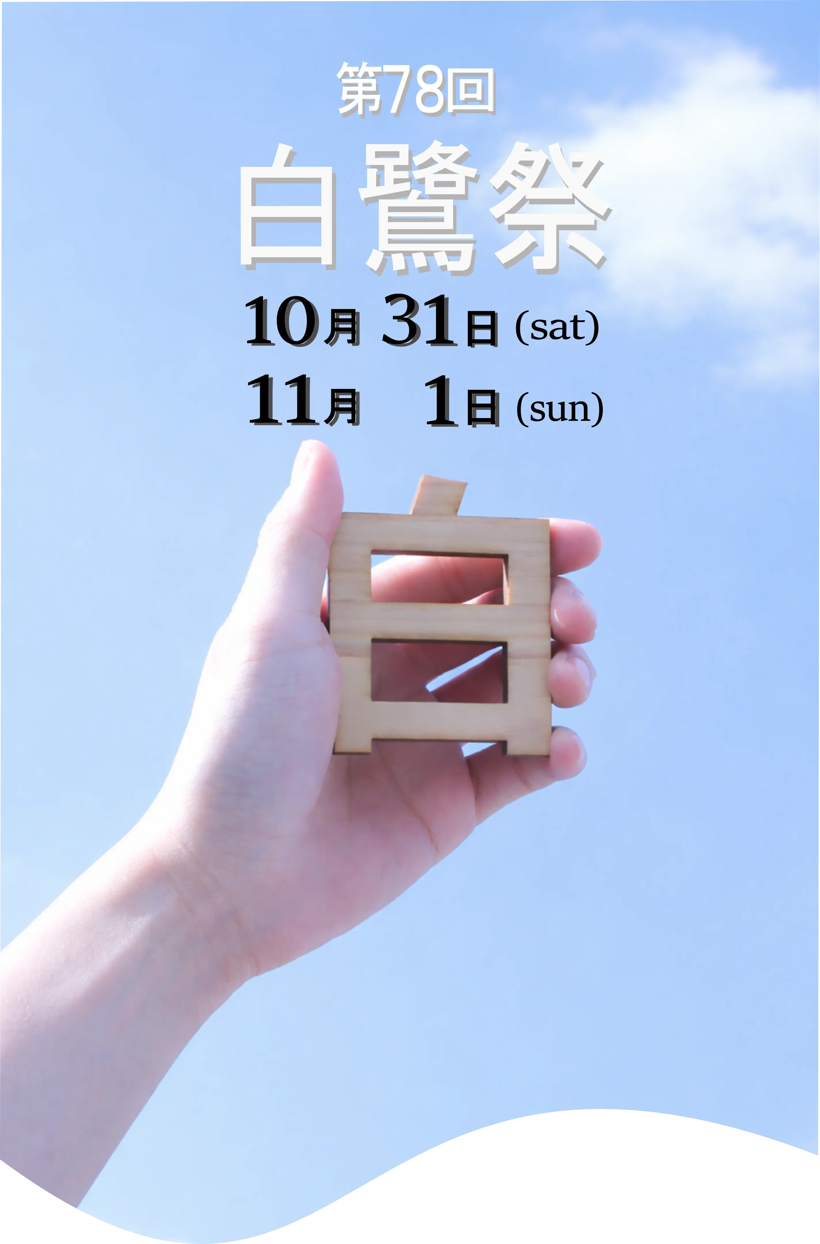 『白』という字の形をした模型を空にかざしている写真